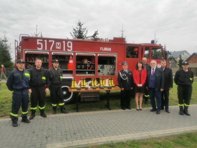 Strażacy OSP na tle samochodu