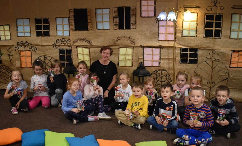 Dzieci i opiekunka na tle dekoracji