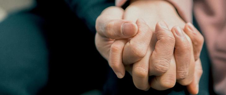 splecione ręce w uścisku na ciemnym tle